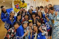 入居者と職員が集合写真を撮影する様子。施設内でのイベントやレクリエーション活動の一場面